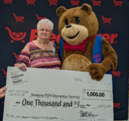 Newberg FISH’s Executive Director with Freddy Bear holding a check of $1000 donated by Fred Meyer